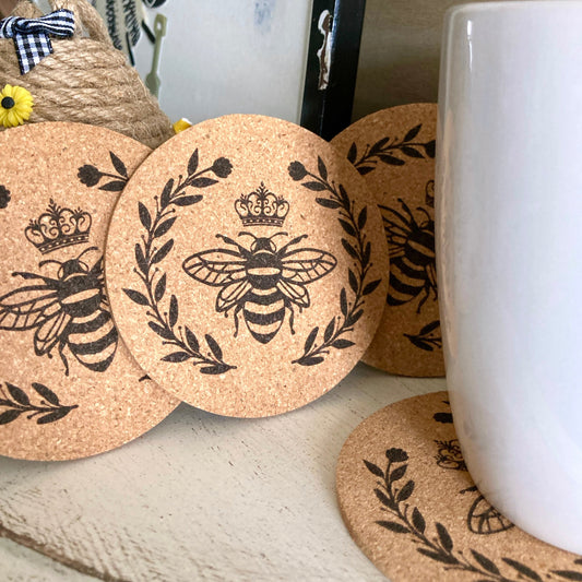 set of 4 bumble bee with crown and surrounded with a laurel of leaves and berries that have been laser engraved on cork