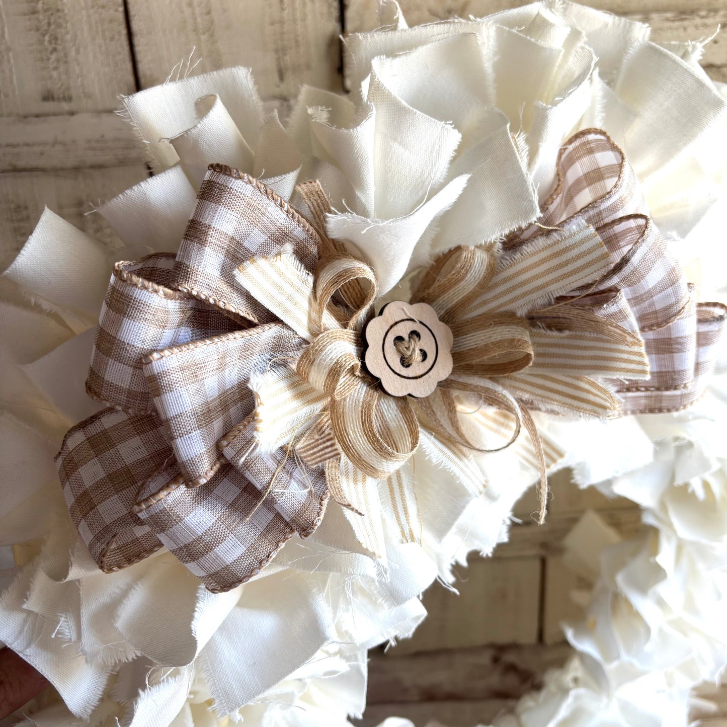 Decorative bow with checkered pattern and wooden button on a white background