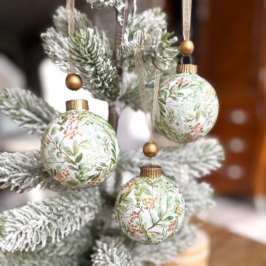 Decorative Christmas ornaments on a frosted tree with a blurred background
