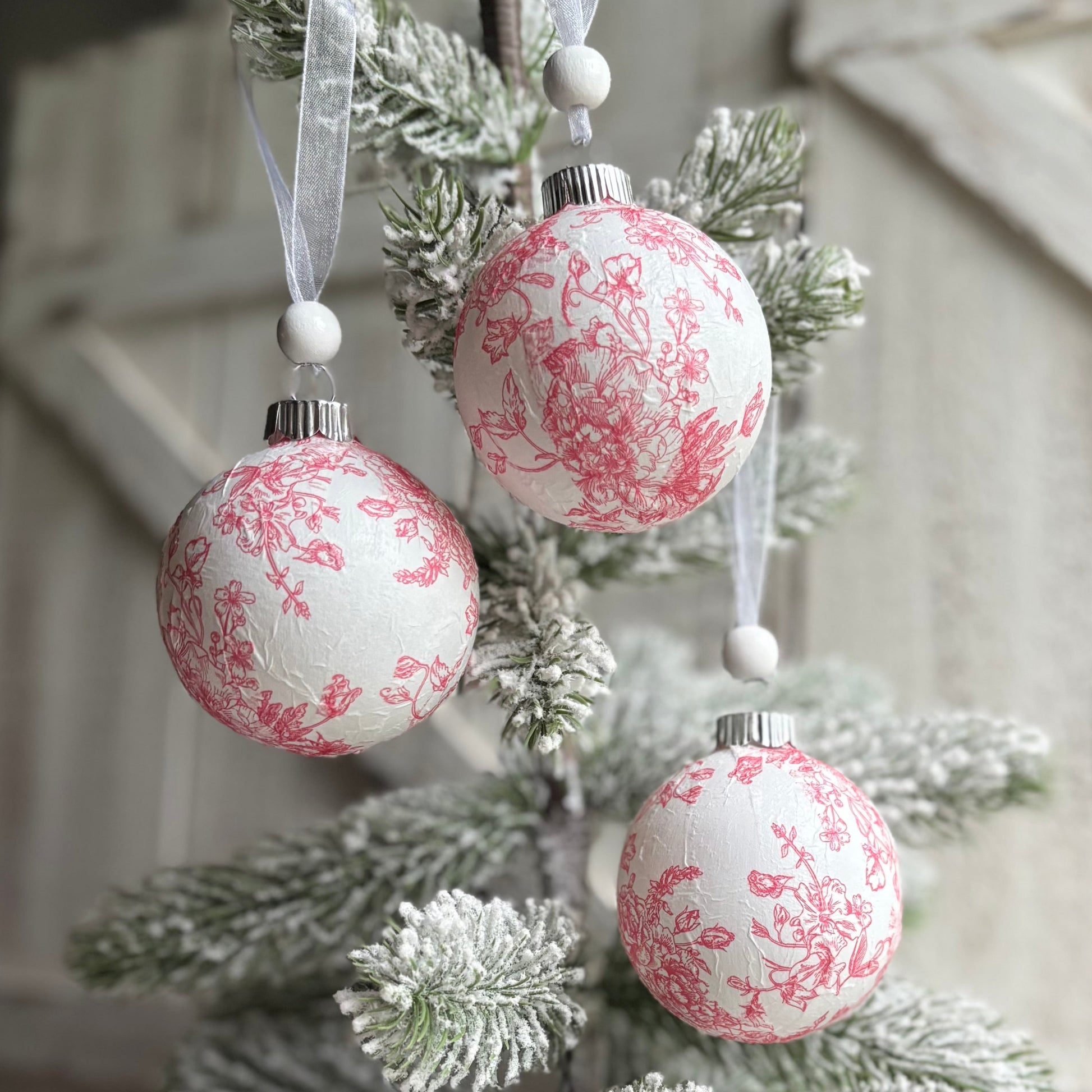 Decorative Christmas tree with pink and white ornaments against a rustic wooden background