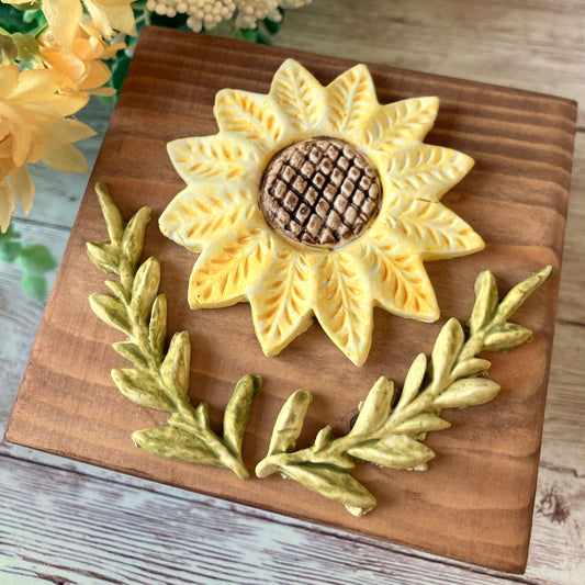 mini 3.5 inch square wooden block stained with a medium color then an clay hand painted sunflower and leaves glued to the top