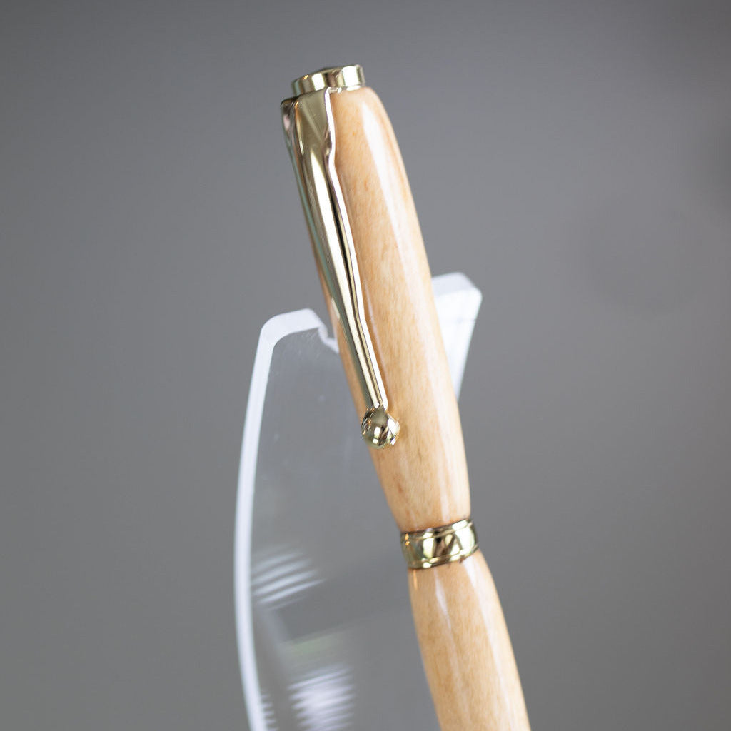 Wooden pen with gold accents on a gray background