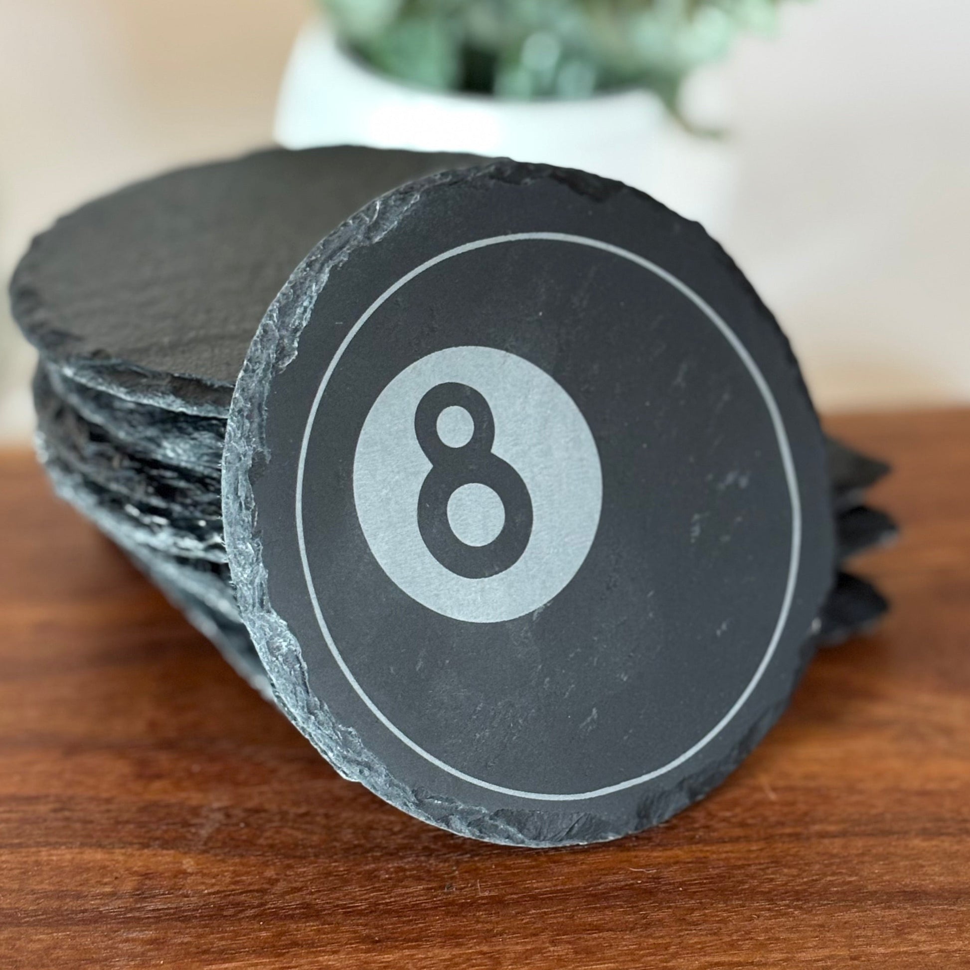 slate coaster with 8 ball design on a wooden surface