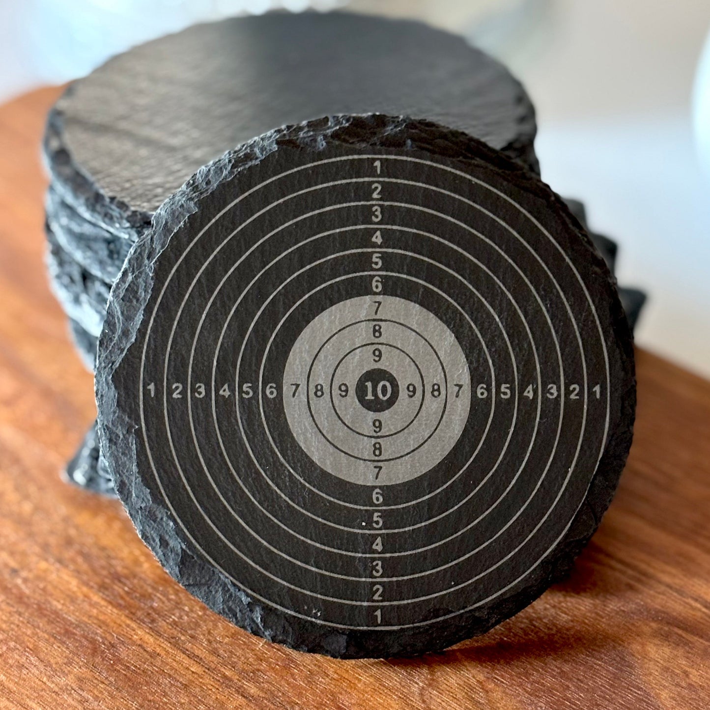 black slate coaster with an archery or shooting target design
