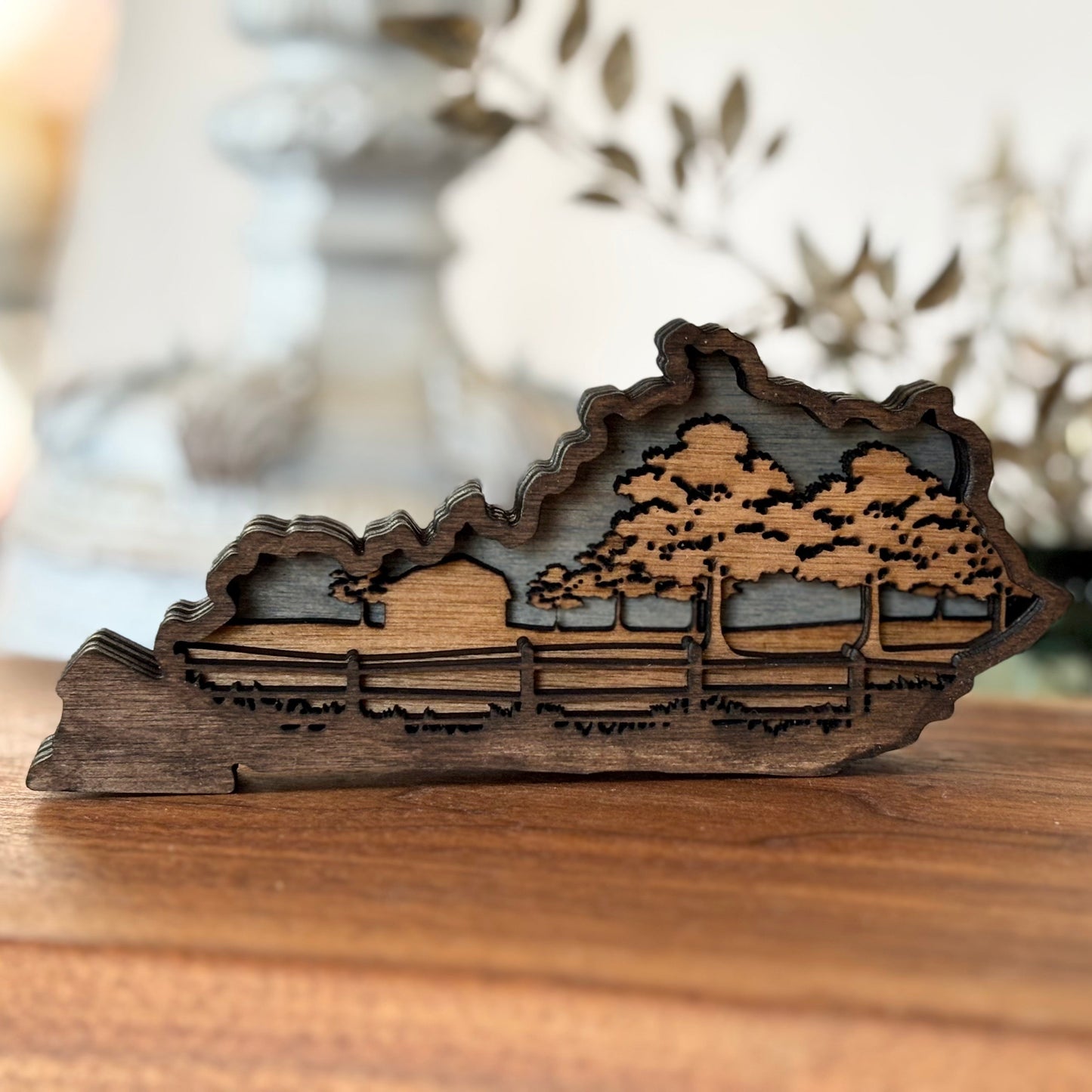 Wooden landscape sculpture on a wooden surface with blurred background. Kentucky home decor