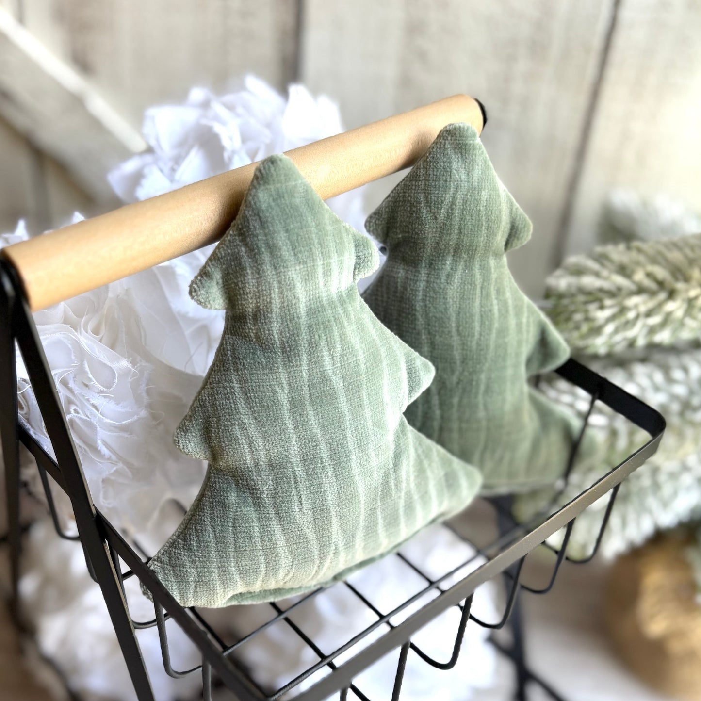 Green textured cushions on a wire basket with a neutral background